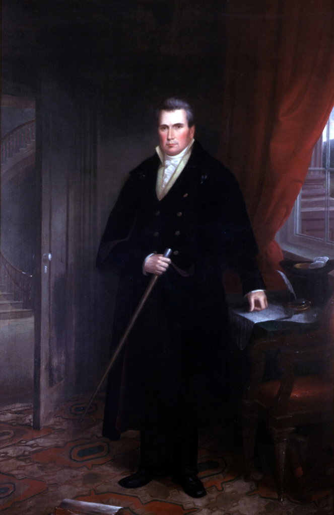 Governor John Clark standing beside a desk